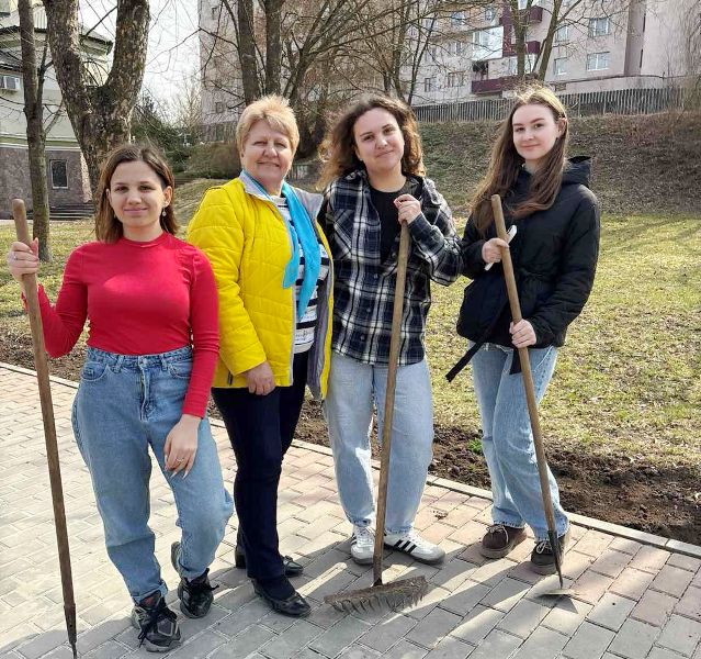 Ольга Бучковська і студенти університету під час прибирання території саду